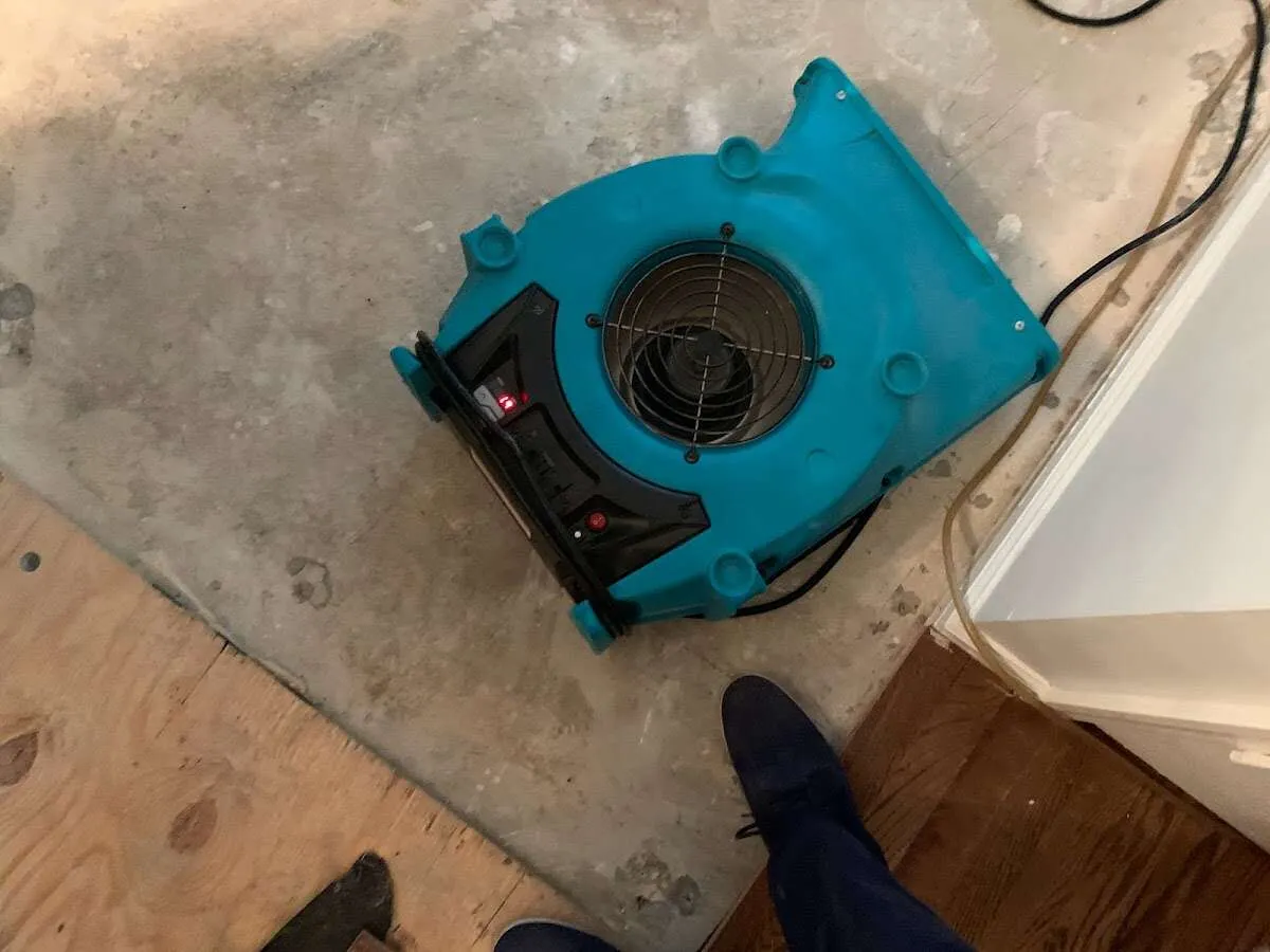 Air mover drying subfloor during Commercial Water Damage Restoration in Leland